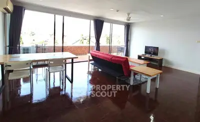 Spacious living room with modern furniture and large balcony access