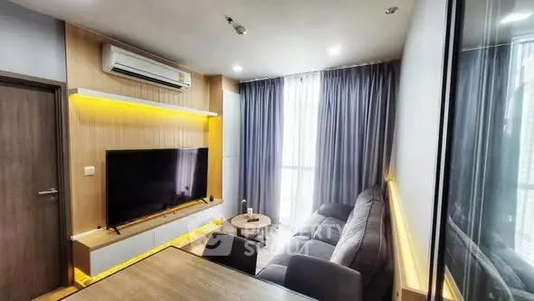 Modern living room with sleek design, large TV, and cozy sofa in a stylish apartment.