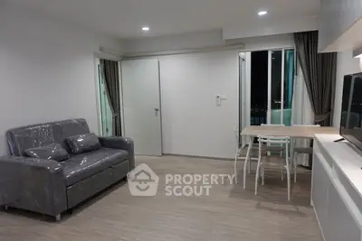 Modern living room with sleek furniture and balcony access, perfect for urban living.