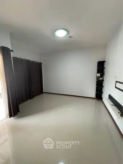 Spacious empty room with glossy tiled floor and modern lighting, ready for customization.