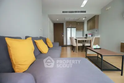 Modern living room with stylish furniture and open kitchen layout in a contemporary apartment.