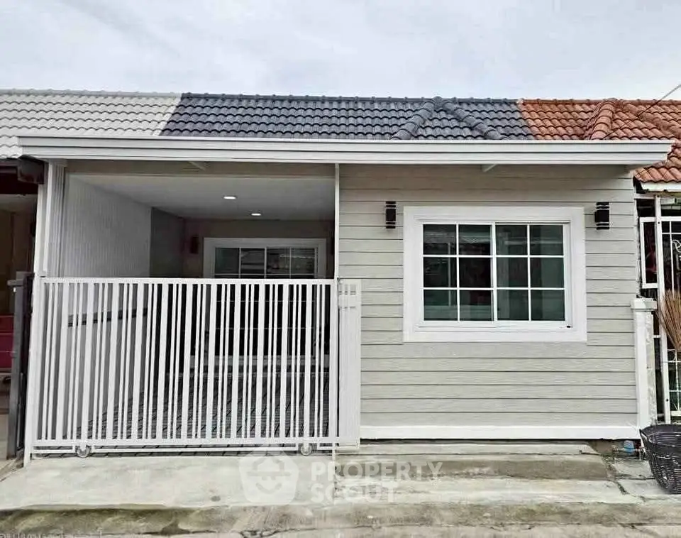 Charming single-story home with modern facade and gated entrance