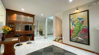 Elegant living room with modern decor and stunning peacock artwork, featuring a stylish bar area.