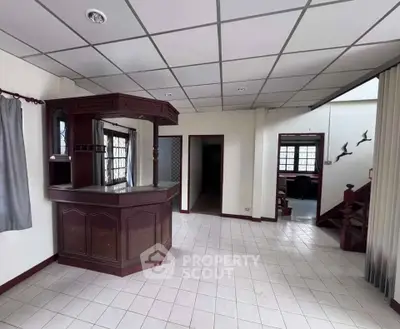 Spacious interior with unique wooden bar and tiled flooring, ideal for entertaining guests.