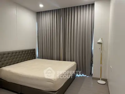 Modern bedroom with elegant design and cozy ambiance, featuring a stylish bed and floor lamp.