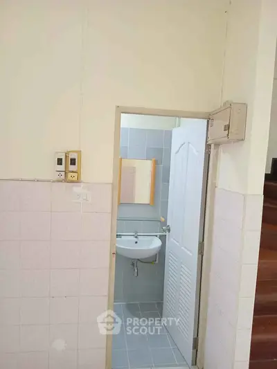 Compact bathroom with sink and tiled walls in a cozy home setting.