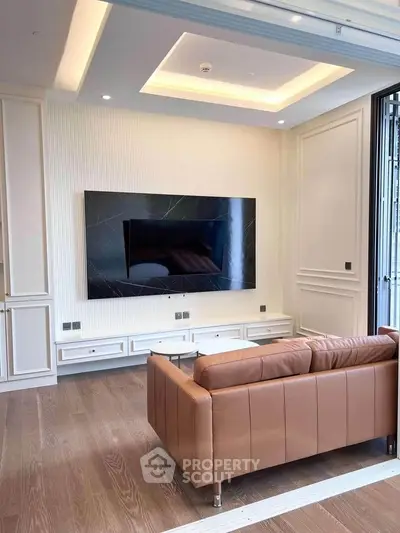 Luxurious living room with modern TV setup and elegant leather sofa