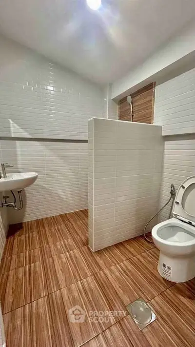 Modern bathroom with sleek white tiles and wooden floor design
