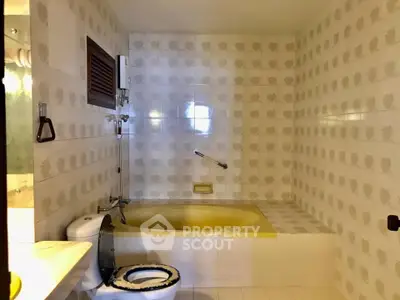 Vintage bathroom with yellow bathtub and retro tile design