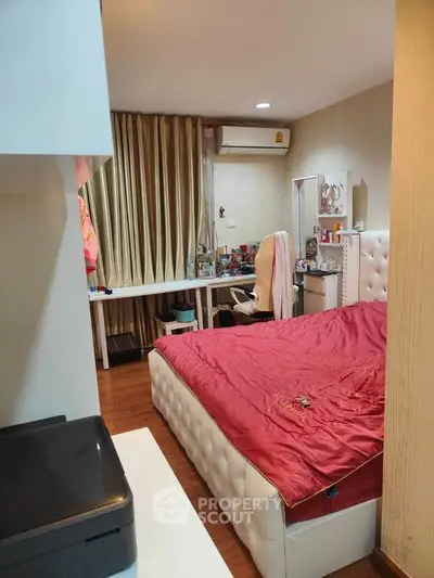 Cozy bedroom with plush bed and study area, featuring warm lighting and elegant curtains.