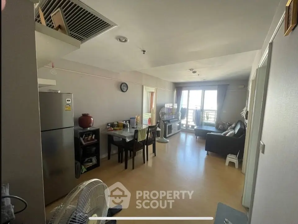 Spacious living room with dining area and balcony view in modern apartment