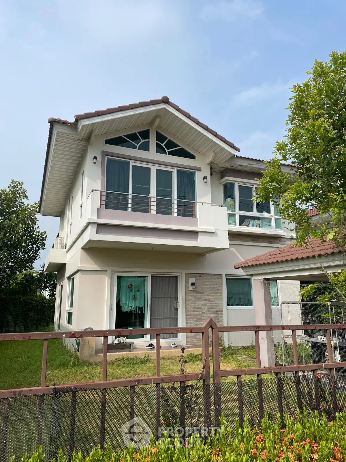 Charming two-story house with a lush garden and modern architectural design, perfect for family living.