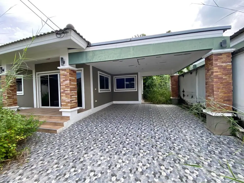 Charming single-story home with spacious carport and modern exterior design.