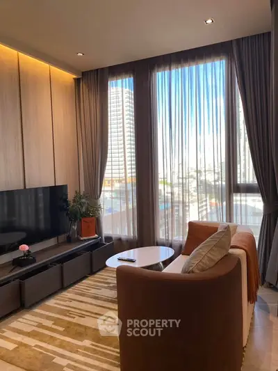 Modern living room with large windows and city view, featuring cozy seating and stylish decor.