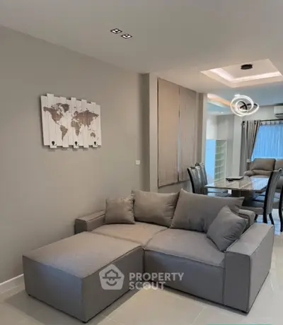 Modern living room with sleek gray sofa and stylish dining area
