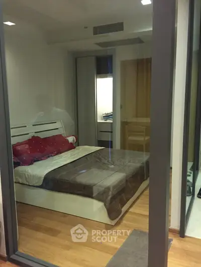 Modern bedroom with glass walls and wooden flooring in a stylish apartment.