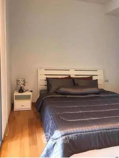 Cozy bedroom with modern decor and wooden flooring, perfect for relaxation.