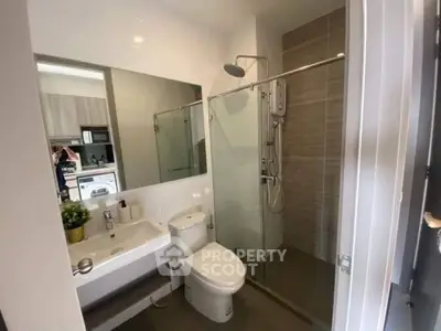 Modern bathroom with glass shower and sleek fixtures in a contemporary apartment.