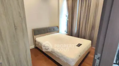Cozy bedroom with modern design and ample natural light, featuring a comfortable bed and elegant curtains.