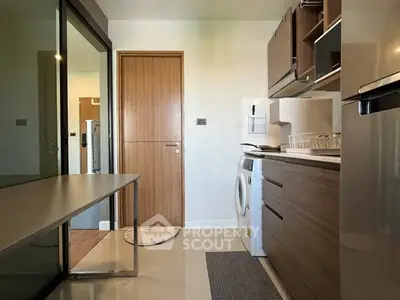 Modern kitchen with sleek cabinetry and built-in washing machine in a stylish apartment.