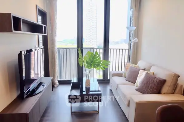 Modern living room with large windows and balcony view in urban apartment.