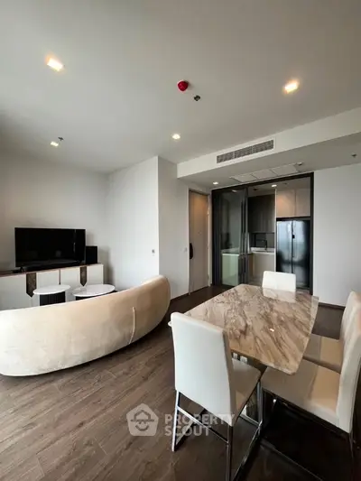 Modern living room with elegant dining area and sleek furniture in a stylish apartment.
