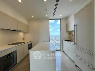 Modern kitchen with sleek cabinetry and stunning city view from large window.