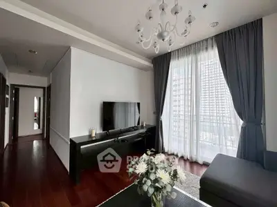Elegant living room with chandelier, large window, and modern TV setup.