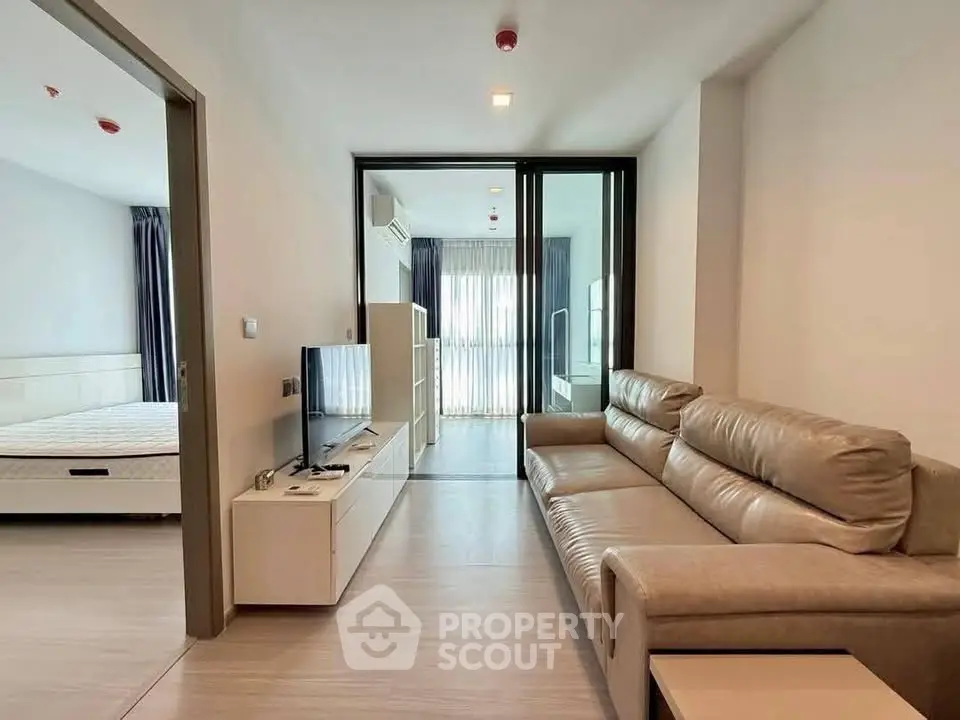 Modern living room with sleek design and spacious layout, featuring a comfortable sofa and large windows.
