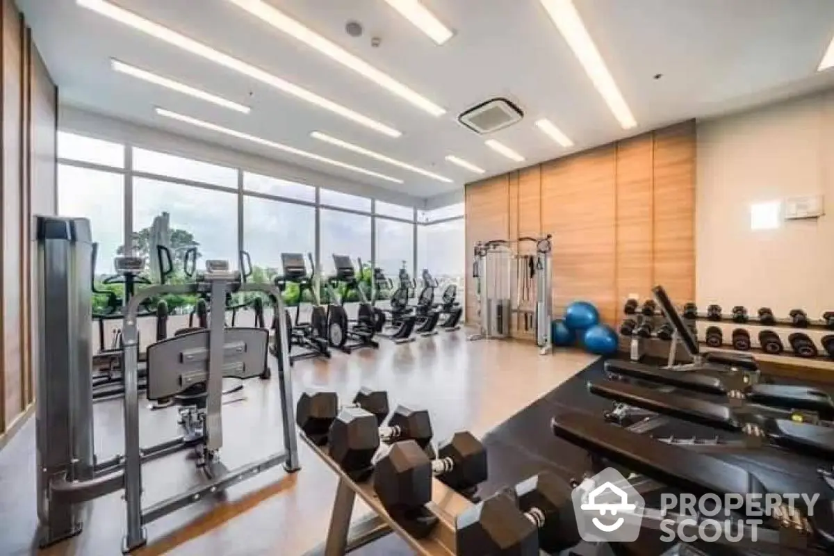 Modern gym with state-of-the-art equipment and large windows offering scenic views.