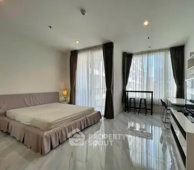 Spacious modern bedroom with large windows and elegant furnishings