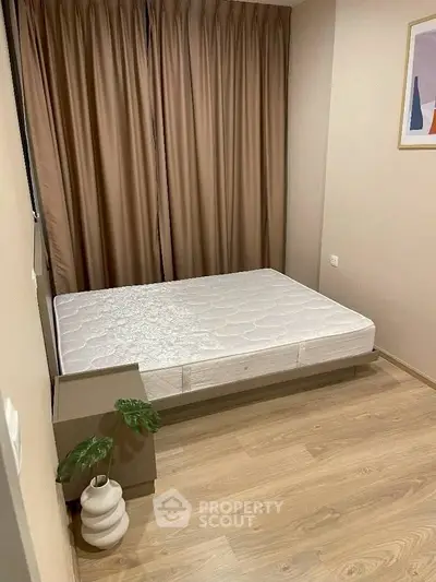 Cozy bedroom with minimalist decor and natural light, featuring a comfortable bed and elegant flooring.