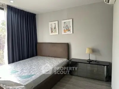 Modern bedroom with large window and stylish decor in a contemporary apartment.