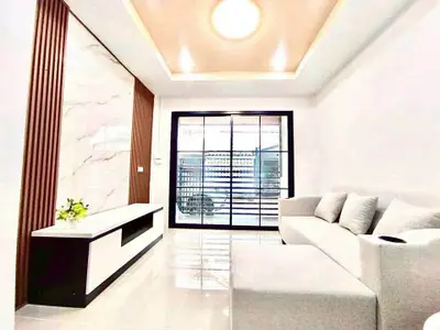 Modern living room with sleek design and large window offering natural light.