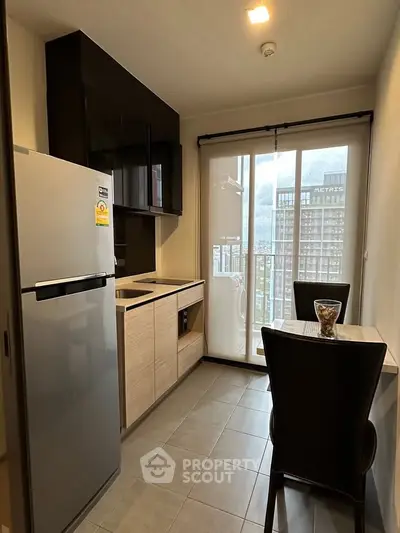 Modern kitchen with sleek design and balcony view in urban apartment