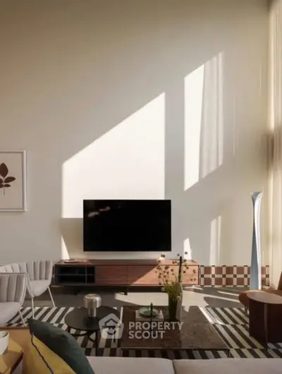 Modern living room with high ceilings, stylish furniture, and large TV setup.