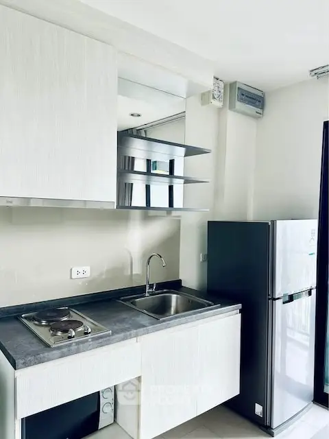 Modern kitchen with sleek cabinetry and stainless steel appliances in a bright apartment.