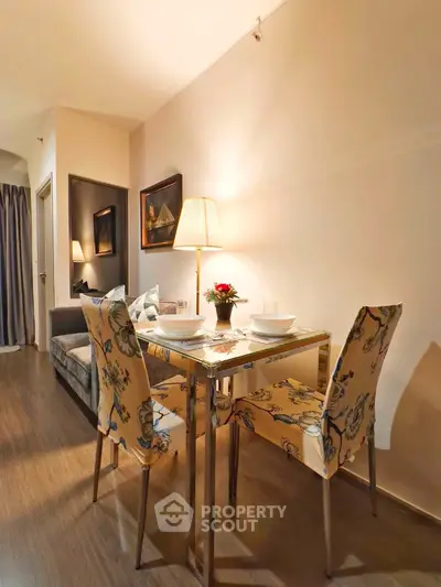 Charming dining area with elegant floral chairs and cozy lighting in modern apartment.