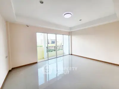 Spacious empty room with large windows and balcony access, perfect for customization.