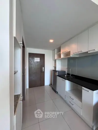 Modern kitchen with sleek cabinetry and stainless steel appliances in a contemporary apartment.