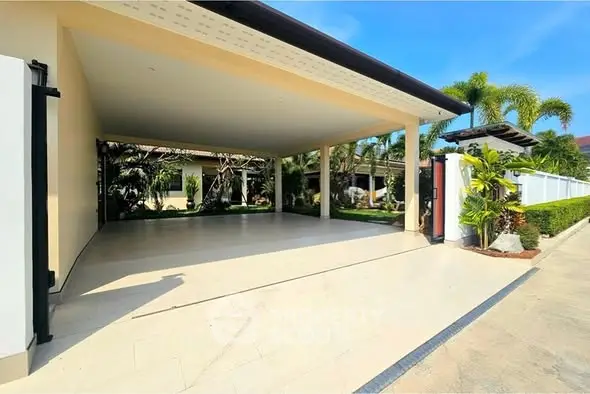 Spacious covered parking area with lush garden surroundings in a modern residential property.