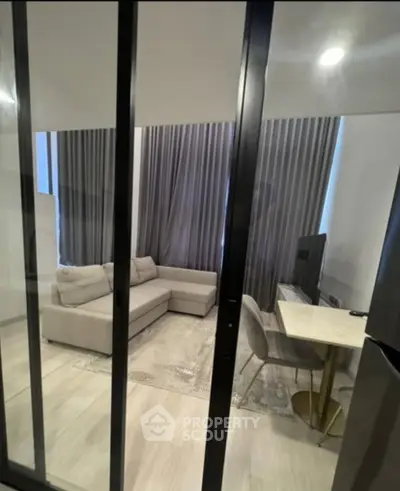 Modern living room with sleek glass doors and elegant furnishings