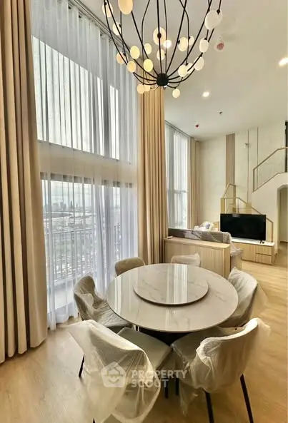 Luxurious modern living room with high ceilings and elegant chandelier