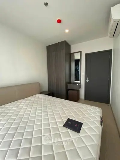 Modern bedroom with minimalist design featuring a comfortable bed and sleek wardrobe.