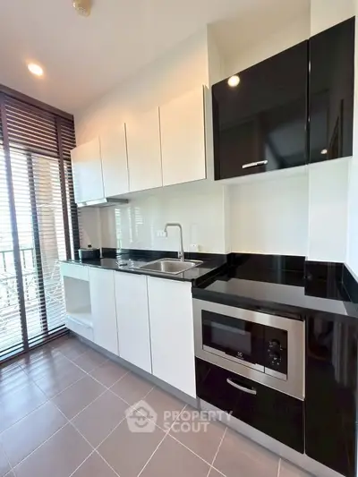 Modern kitchen with sleek black and white cabinetry and built-in appliances