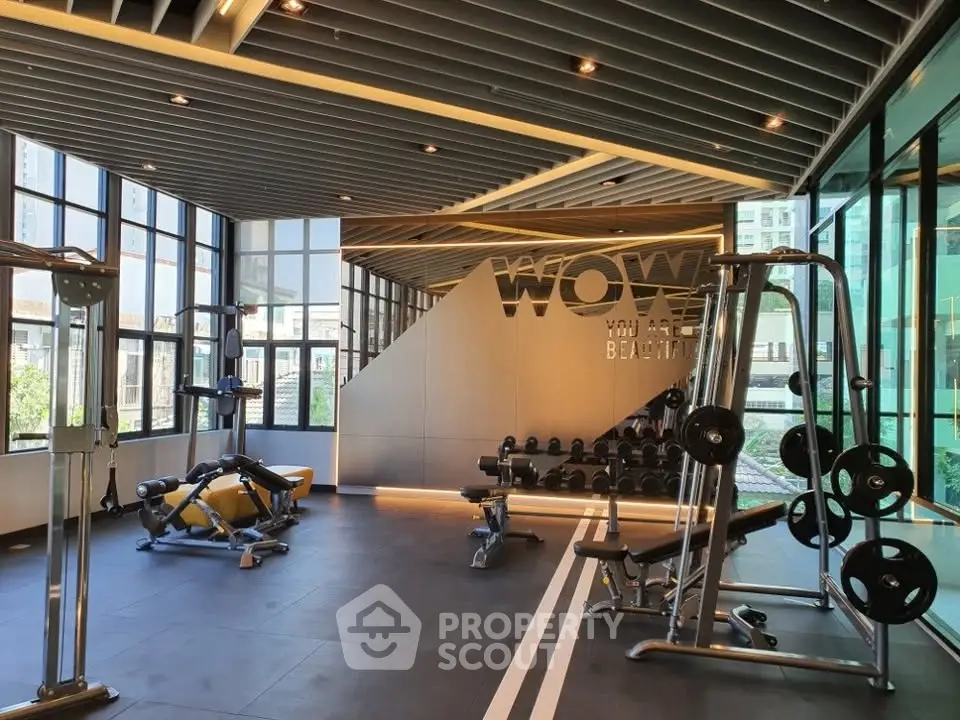 Modern gym with state-of-the-art equipment and large windows offering a bright and inviting workout space.