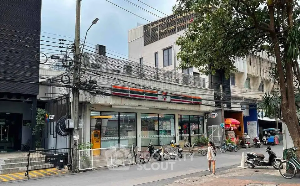 Street view of commercial building with convenience store and parked motorcycles.