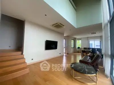 Spacious modern living room with high ceiling and elegant wooden flooring