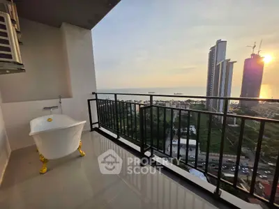 Luxurious balcony with stunning ocean view and elegant freestanding bathtub at sunset.
