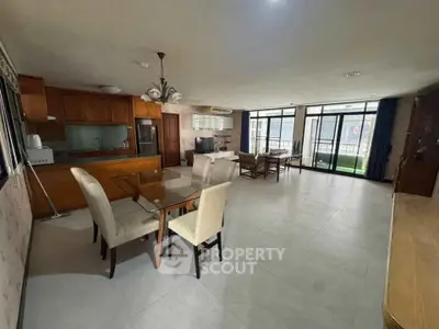 Spacious open-plan living and dining area with modern kitchen and large windows.